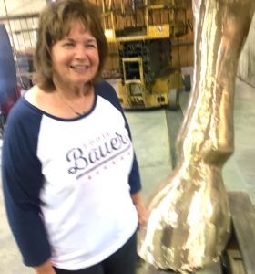 Bev Paddleford, one of the owners and founders of Eagle Bronze, shows the relative size of the horses by standing next to a hoof.